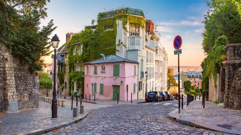 Cozy old street with pink house at the sunny sunrise, quarter Montmartre in Paris, France