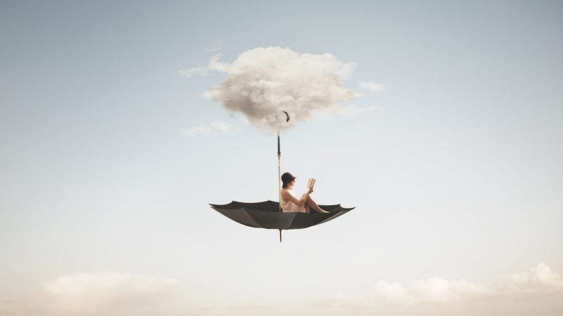 surreal woman reading a book flies on an overturned umbrella